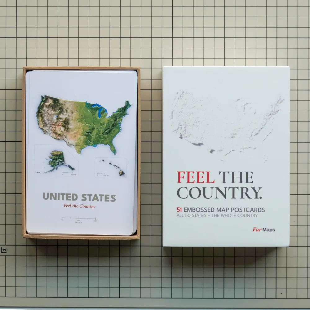 Far Maps rigid lift-off-lid box sample: the base holding the United States proof card, beside the lid printed Feel the country, 51 embossed map postcards