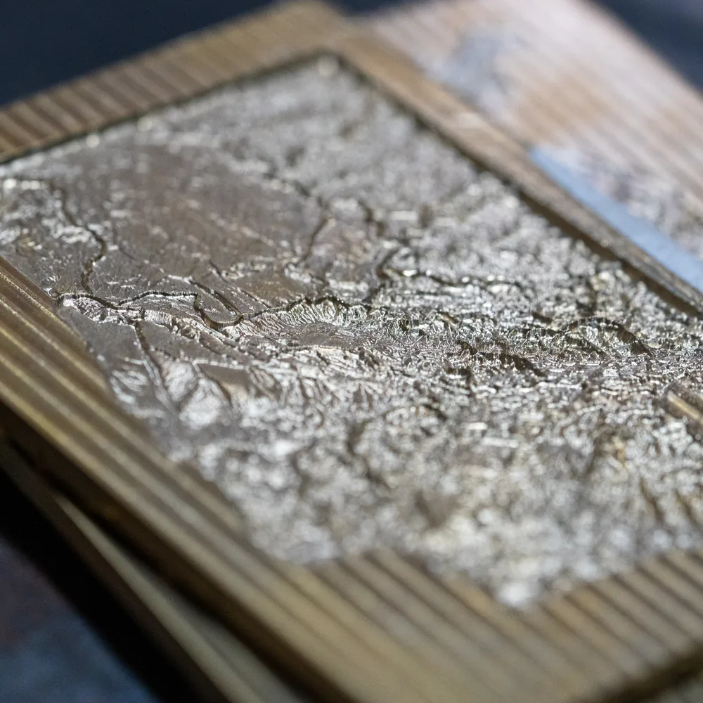 Close-up of the Washington metal embossing die showing detailed raised terrain