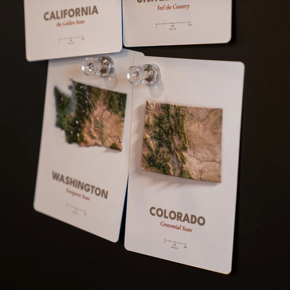 Four Far Maps production proofs pinned vertically to a black display board