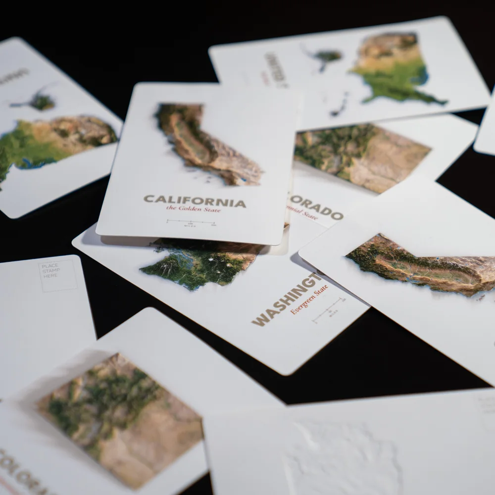 A spread of Far Maps production proofs showing raised fronts with one postcard back visible