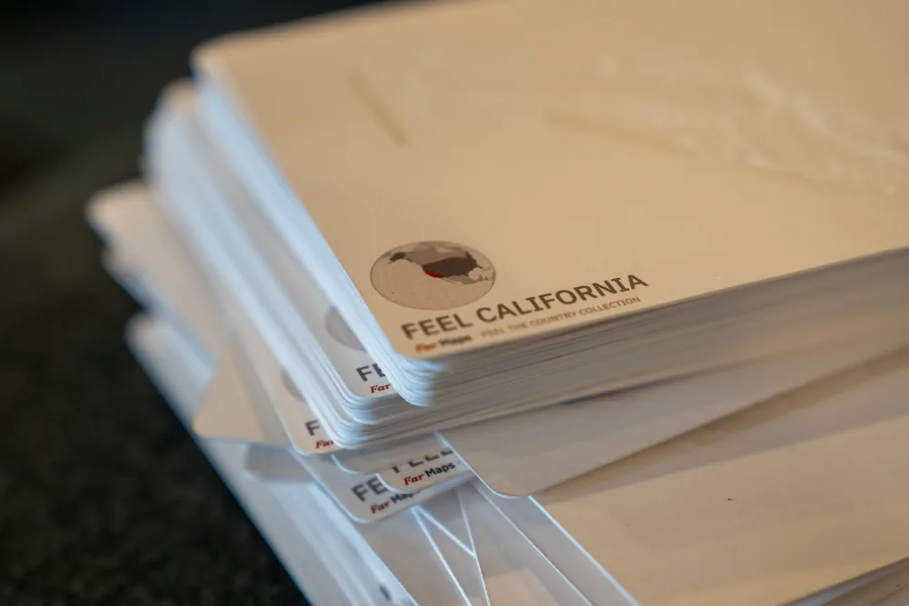 California raised-relief production proof resting above the printed backs of other proof cards