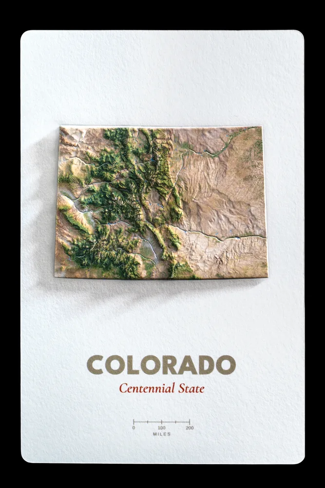 Colorado production proof photographed straight on, the raised Rocky Mountains meeting the flat eastern plains above the printed state name